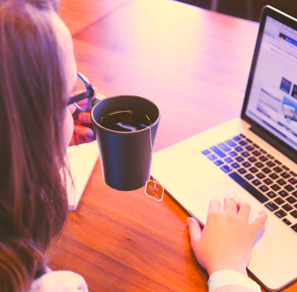 Picture of woman drinking coffee at her computer